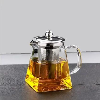 Clear glass teapot infuser with silver lid filled with golden tea from decorbites glass teapot tea set