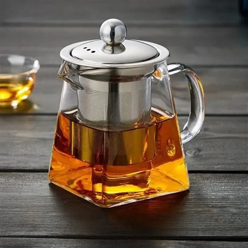 Clear decorbites glass teapot with stainless steel lid handle and built-in infuser holding amber tea liquid