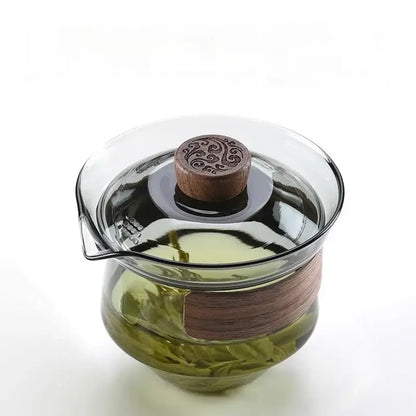 Clear glass teapot set with dark wood lid and handle featuring carved knob in DecorBites glass teapot collection
