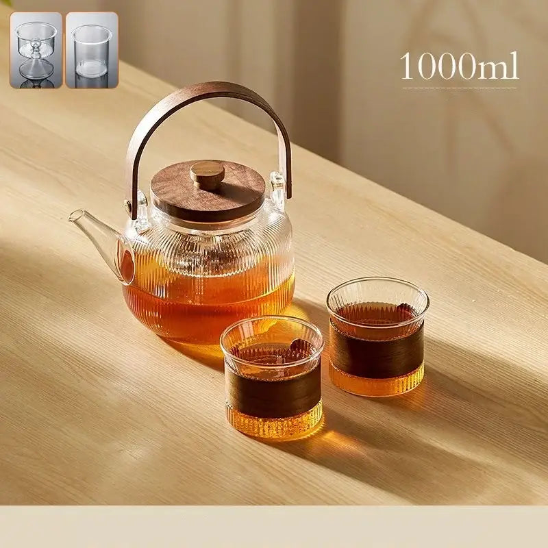 DecorBites glass teapot set with clear glass body and wooden handle and lid filled with amber tea
