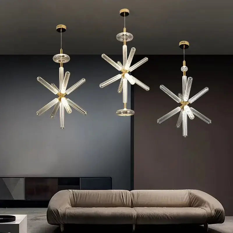 Three modern DecorBites glass tubes pendant lamps with clear glass arms and gold-toned metal fixtures