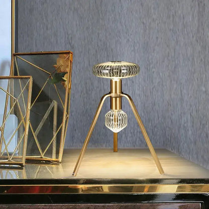 Gold-toned tripod table lamp with geometric wireframe design and illuminated glass tubes led by DecorBites glass tubes