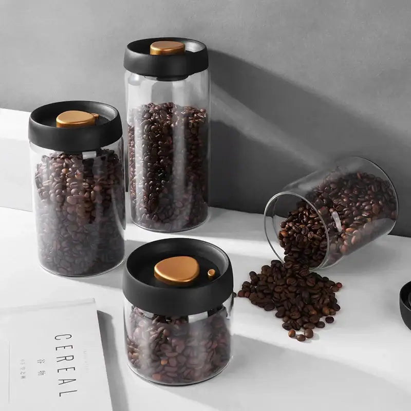 Clear glass coffee bean storage jars with black lids and gold heart seals by decorbites glass vacuum sealed canister