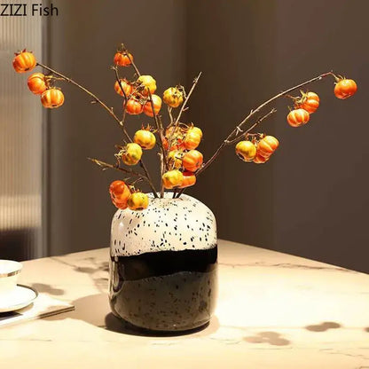 Speckled ceramic decorbites glass vase with black and white two-tone design holding orange and yellow berries ideal for hydroponics flower use