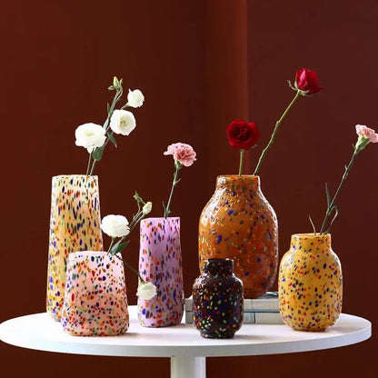 A collection of decorbites glass vases with colorful speckled dots in various shapes and sizes for home decor and hydroponics