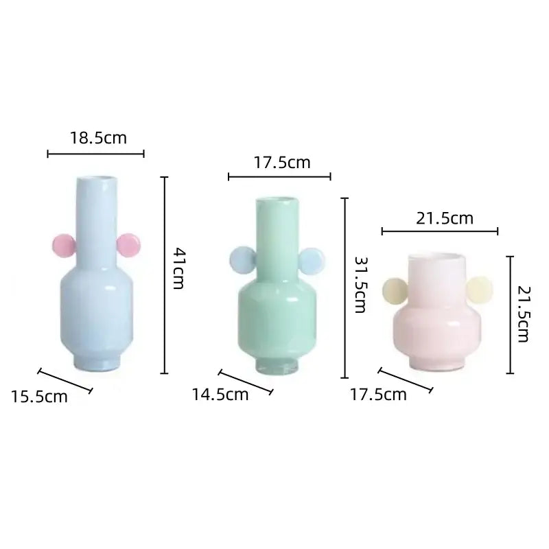 Pastel-colored decorbites glass vase with rounded body, slender neck, and soft pink and light blue spherical handles for floral arrangement