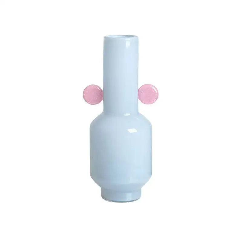 A sleek light blue ceramic decorbites glass vase with two glossy pink spherical handles for floral arrangement