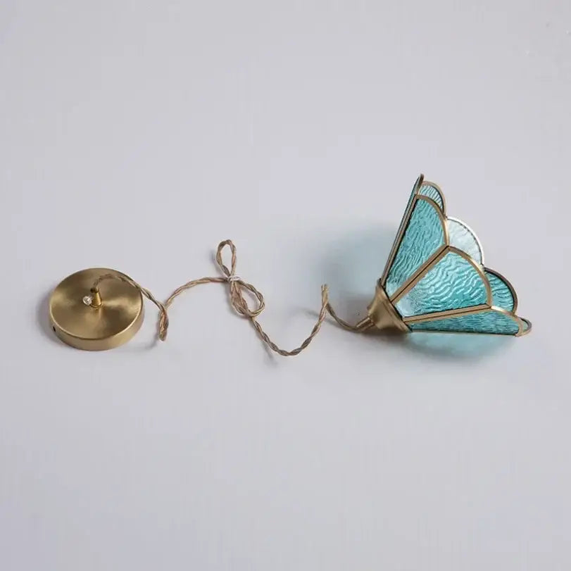 A delicate turquoise decorbites glass vintage pendant light with gold-toned metal framing and brass ceiling mount
