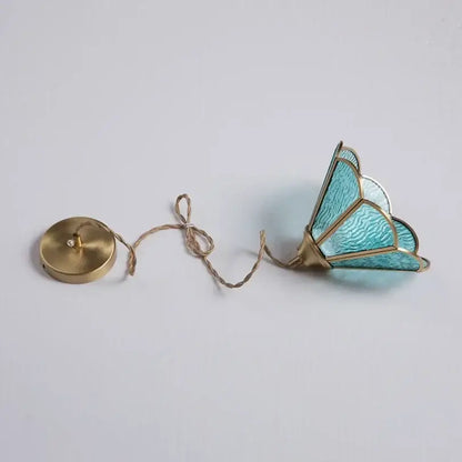 A delicate turquoise decorbites glass vintage pendant light with gold-toned metal framing and brass ceiling mount