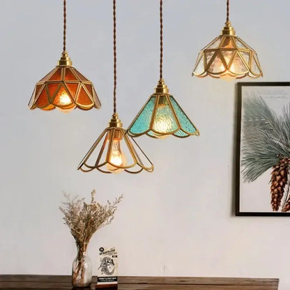Three decorbites glass vintage pendant lights with brass frames and amber teal clear stained glass shades hang elegantly