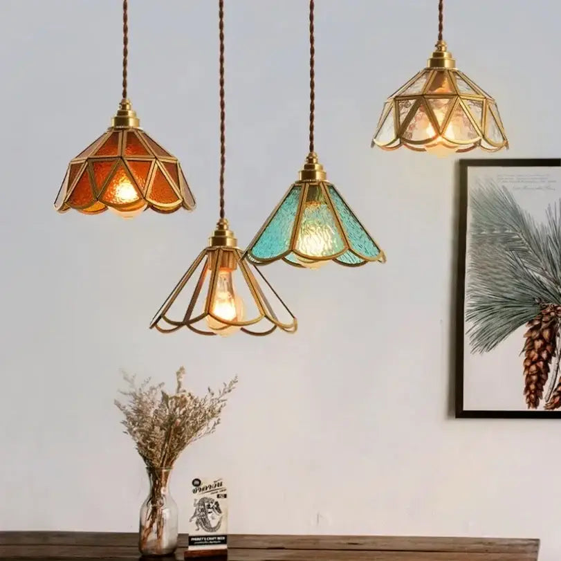 Three decorbites glass vintage pendant lights with brass frames and amber teal clear stained glass shades hang elegantly