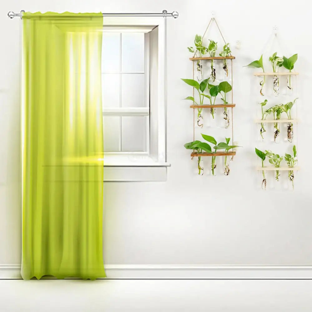 Lime green sheer curtain hanging from a silver rod beside DecorBites™ glass wall hanging planters with wooden holder and test tubes