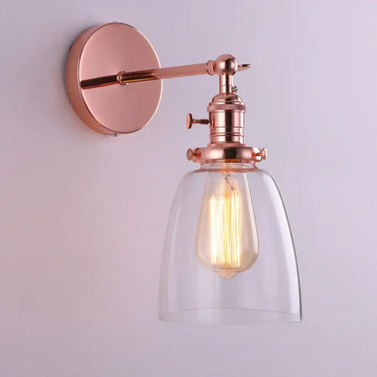 Rose gold vintage-style glass wall lamp with clear shade and exposed filament bulb for living room and bedroom lighting