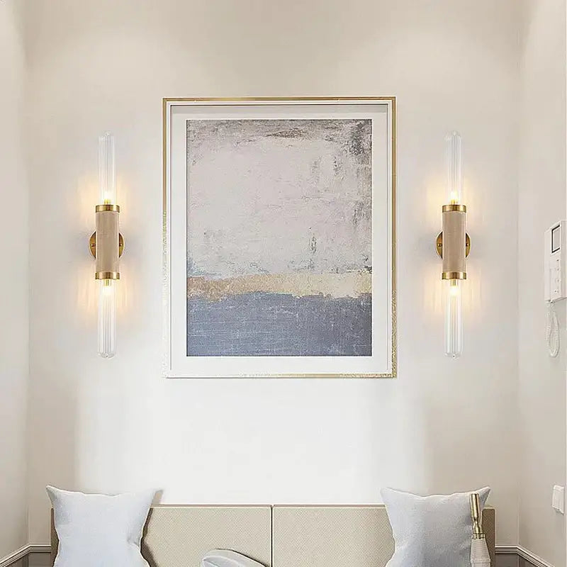 Gold-toned DecorBites glass wall lamp with clear glass tubes and beige cylindrical shades LED light for home decor