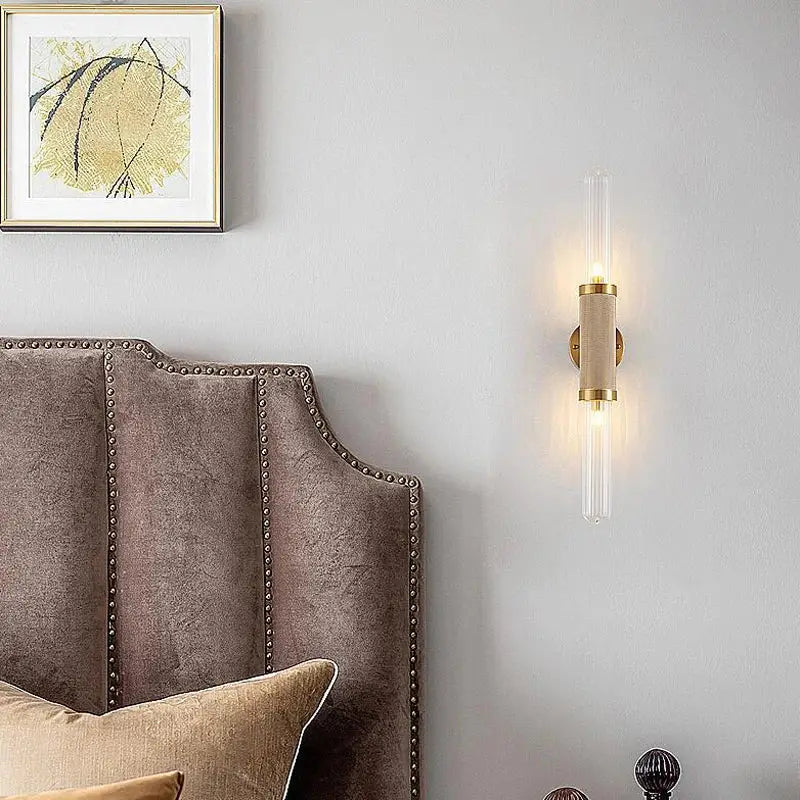 Modern decorbites glass wall lamp with cylindrical beige fabric body, brass accents, clear glass tubes, and led light illumination