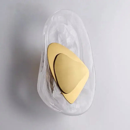 A sleek translucent glass wall lamp with polished gold triangular accent from DecorBites glass wall collection
