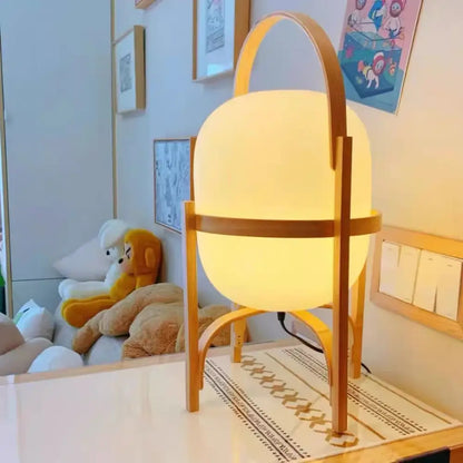 Warm softly glowing decorbites glass and wood metal table lamp with minimalist wooden frame and handle for japanese style room