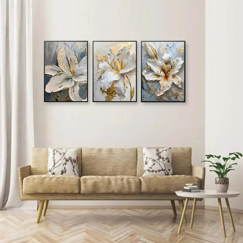 Three framed decorbites gold and white floral 3d canvas wall art featuring white lilies with gold accents above sofa
