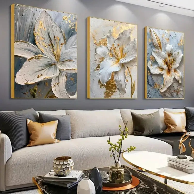 Three framed DecorBites gold and white floral 3D canvas wall art featuring white flower canvas posters above gray sofa