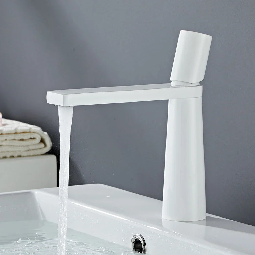 Modern white ceramic basin faucet with tall cylindrical base featuring brushed gold brass accents for bathroom sink