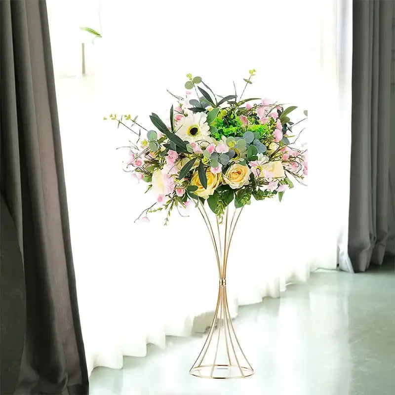 A gold-toned iron flower vase set by decorbites holding soft pink yellow and white artificial flowers for wedding decor