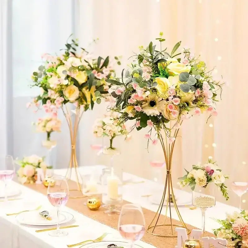 Elegant gold-toned iron flower vase set with tall slender legs and cascading pink yellow roses for wedding decor