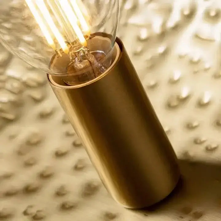 A warm-glowing edison bulb on a brushed brass base in the gold lotus leaf pendant light by decorbites