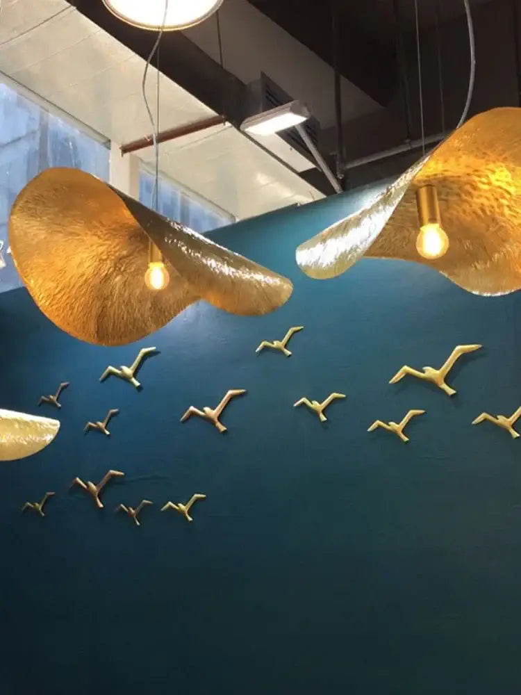 DecorBites gold lotus leaf pendant light with hammered texture and warm glow in sleek metallic finish hanging from ceiling