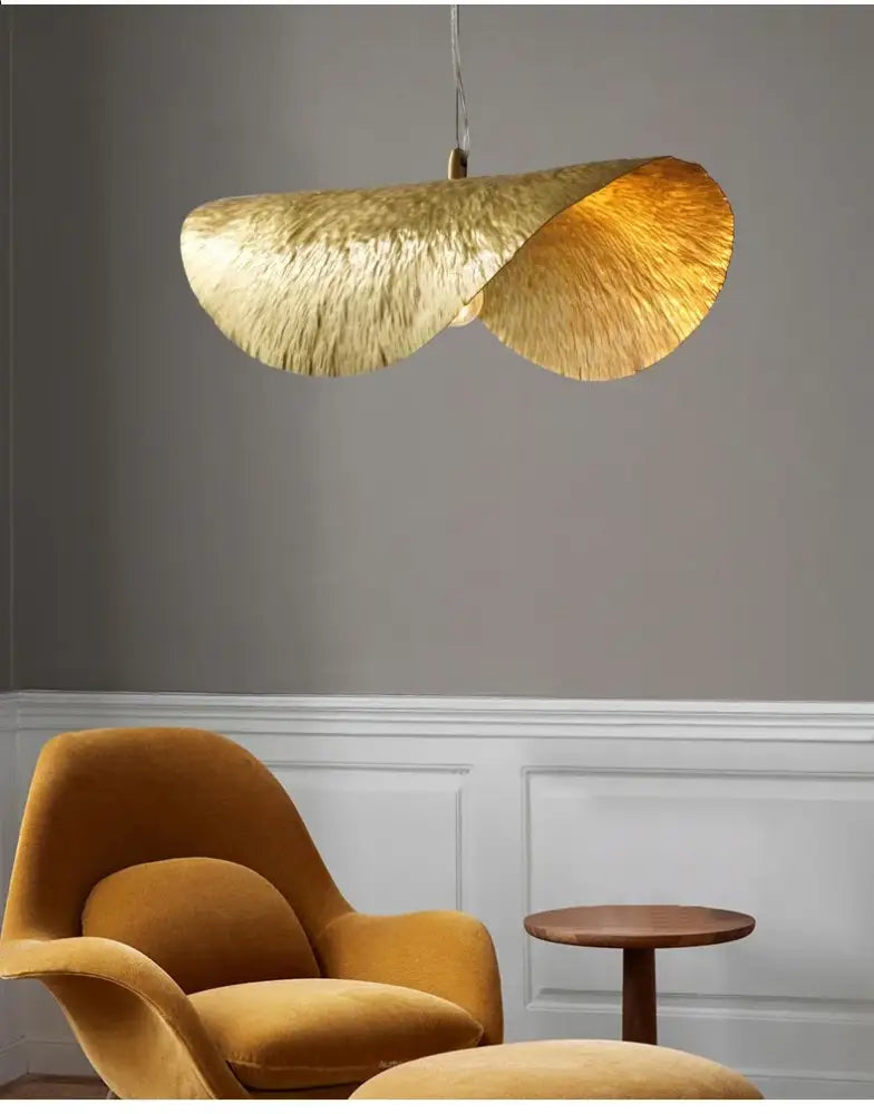 Gold lotus leaf pendant light by decorbites featuring a textured hammered metal finish in a modern lotus leaf design