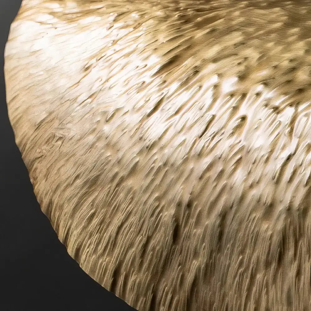 DecorBites gold lotus leaf pendant light with a textured hammered finish on a golden brass circular table top