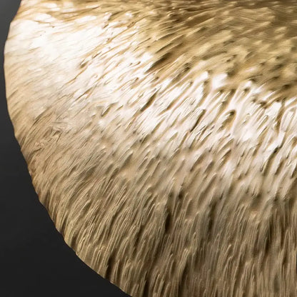 DecorBites gold lotus leaf pendant light with a textured hammered finish on a golden brass circular table top
