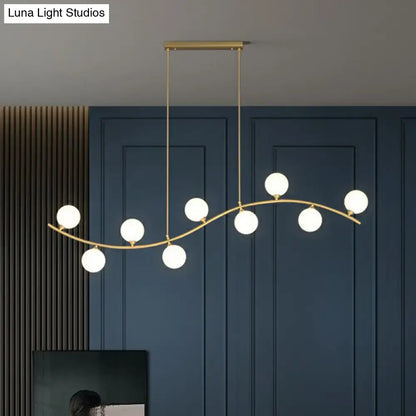 DecorBites gold milk ball glass pendant lighting with seven white glass bulbs on a minimalist wavy ceiling arm