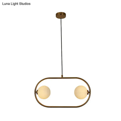 Modern globe hanging brass finished pendant light with two frosted glass globe bulbs in an oval metal frame