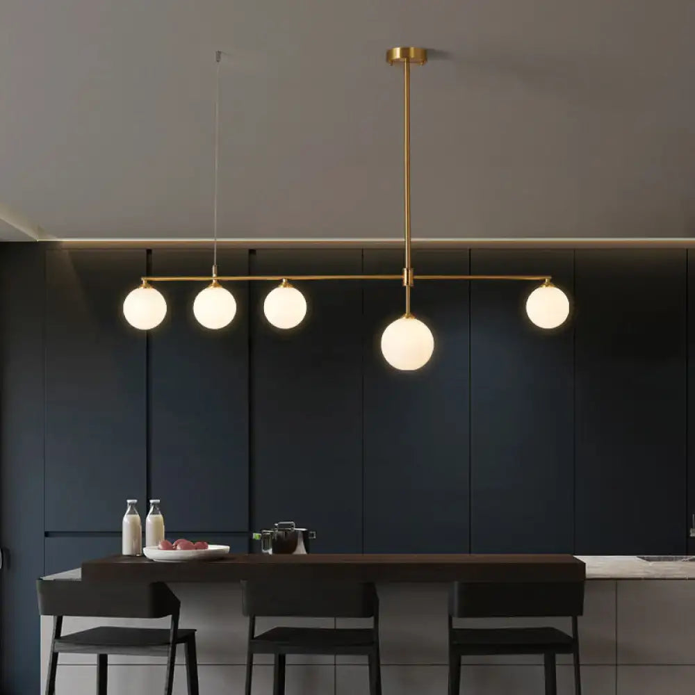 Modern brass ceiling light with five frosted globe shades for dining room by DecorBites™ opaline glass pendant light