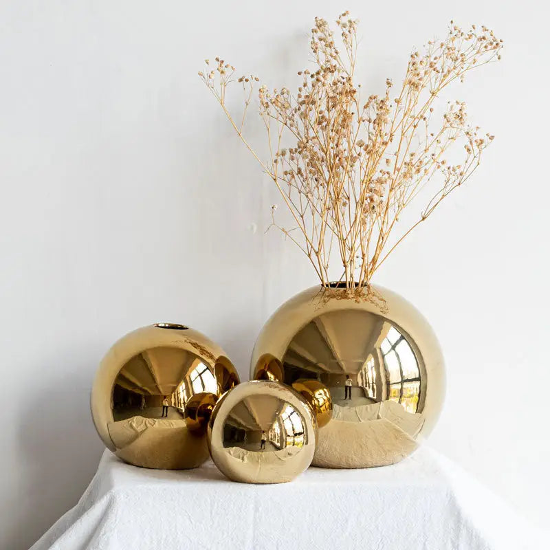 Decorbites golden ball ceramic vases in reflective gold finish arranged in varying sizes for elegant home decor