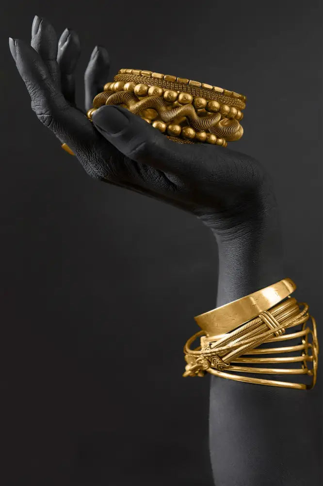 A stack of ornate gold bangles with intricate woven and beaded designs in DecorBites™ golden jewelry african woman canvas art