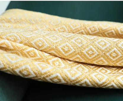 Decorbites golden knitted blanket in golden yellow woven fabric with cream geometric pattern for living room use