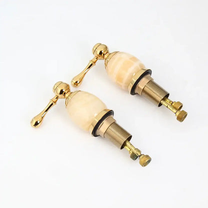 Pair of decorbites golden plated bathtub faucet handles in cream marble finish with polished gold-tone ornate levers