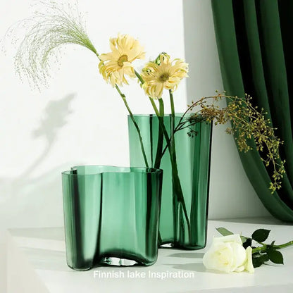 Two translucent emerald green glass vases with wavy organic contours from DecorBites green glass vase collection