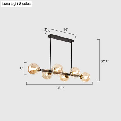Black metal chandelier featuring five amber hand-blown dimpled glass globe bulbs for modern restaurant lighting