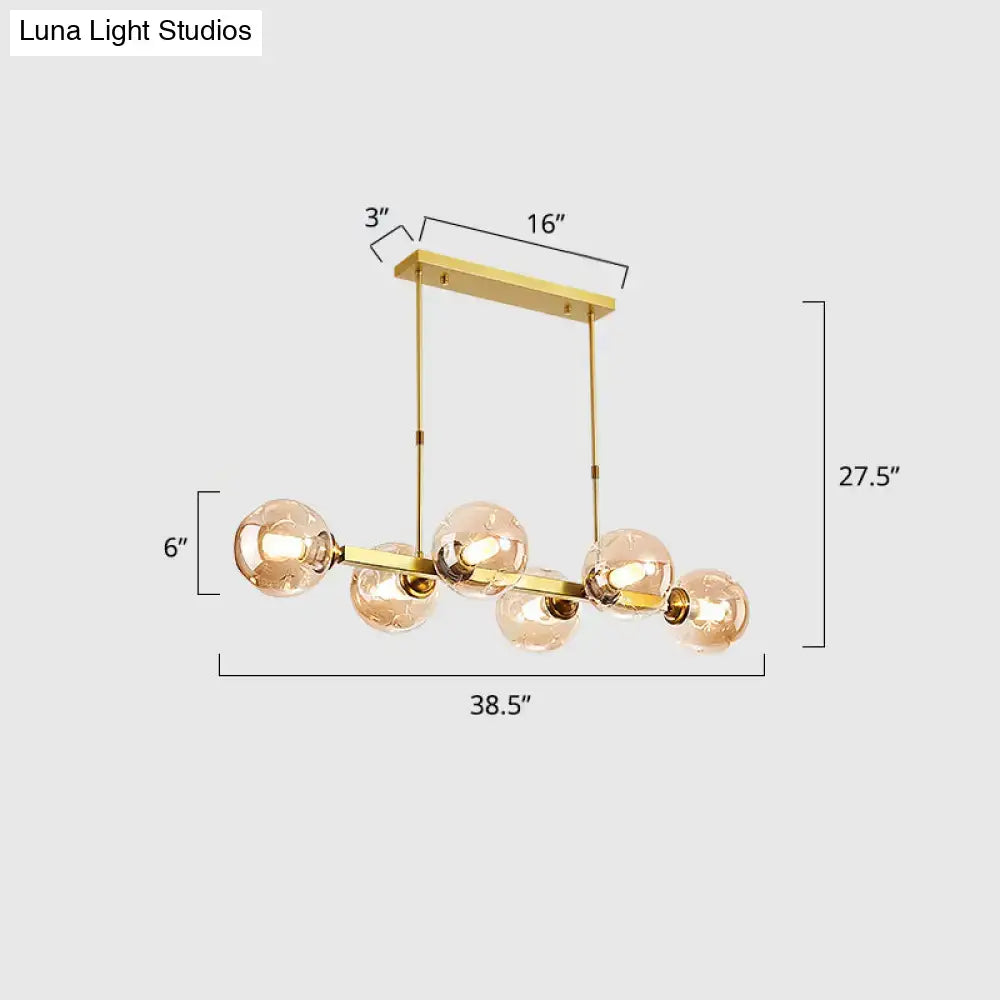 Gold-toned decorbites™ hand-blown dimpled glass island pendant lamp with five spherical bulbs for modern restaurant decor