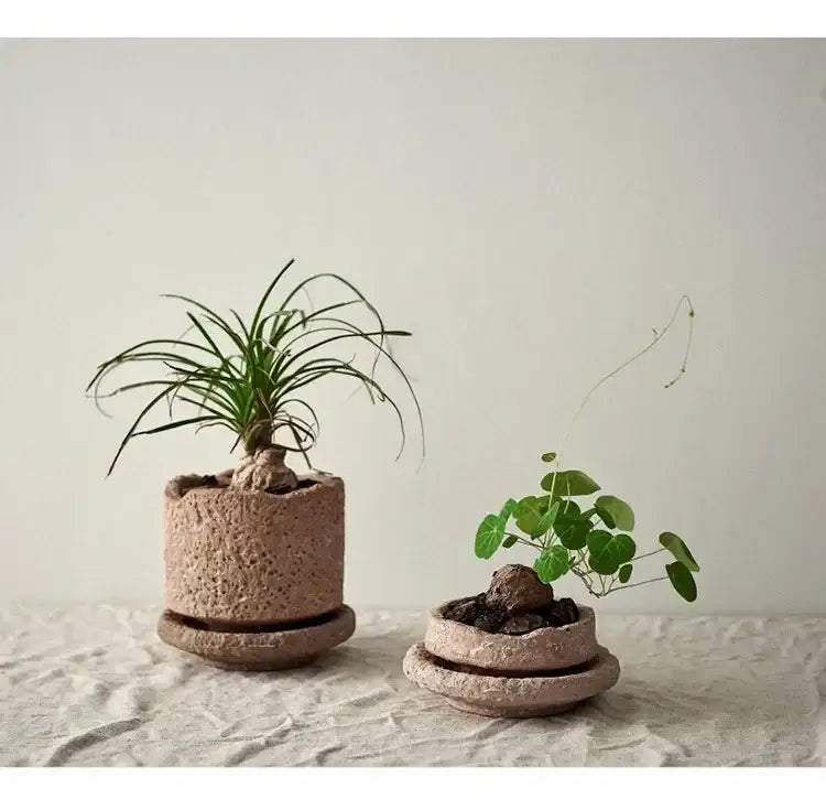 Two earth-toned handcrafted ceramic vases with textured pottery finish and matching saucers for flowers by DecorBites