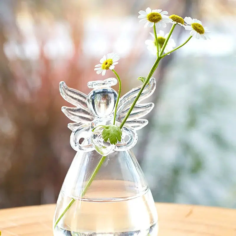 DecorBites™ handmade clear glass angel vase with delicate wings and halo holding white daisies for home decor