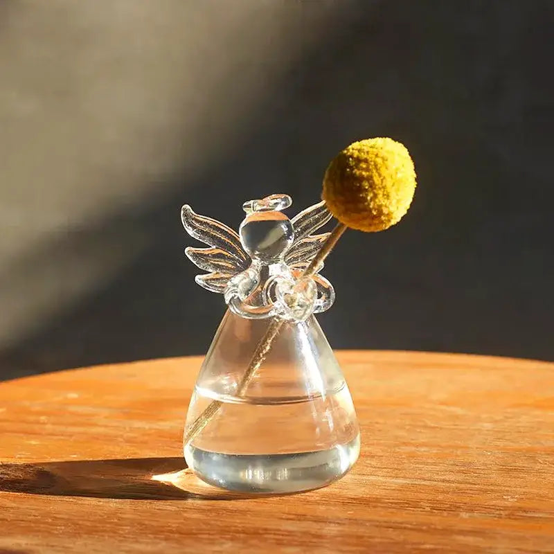 Clear glass angel-shaped vase holding a single yellow ballflower for home decor by DecorBites™