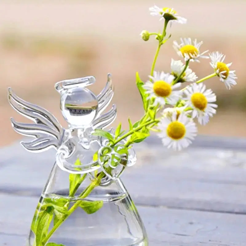 Clear glass angel-shaped handmade vase by DecorBites holding white daisies with yellow centers for home decor