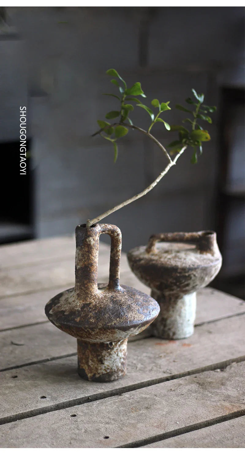 Rustic brown ceramic vase with handle and textured surface holding a green branch for dried flowers by decorbites