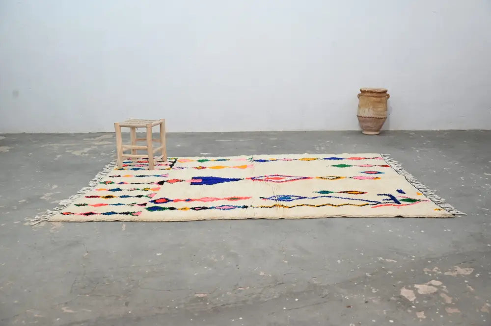 Cream-colored DecorBites™ handmade moroccan azilal carpet 240x160 cm with vibrant geometric patterns and fringed edges