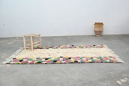 Colorful handmade Moroccan azilal rug 222x133 with cream central field and vibrant multicolored fringe by DecorBites