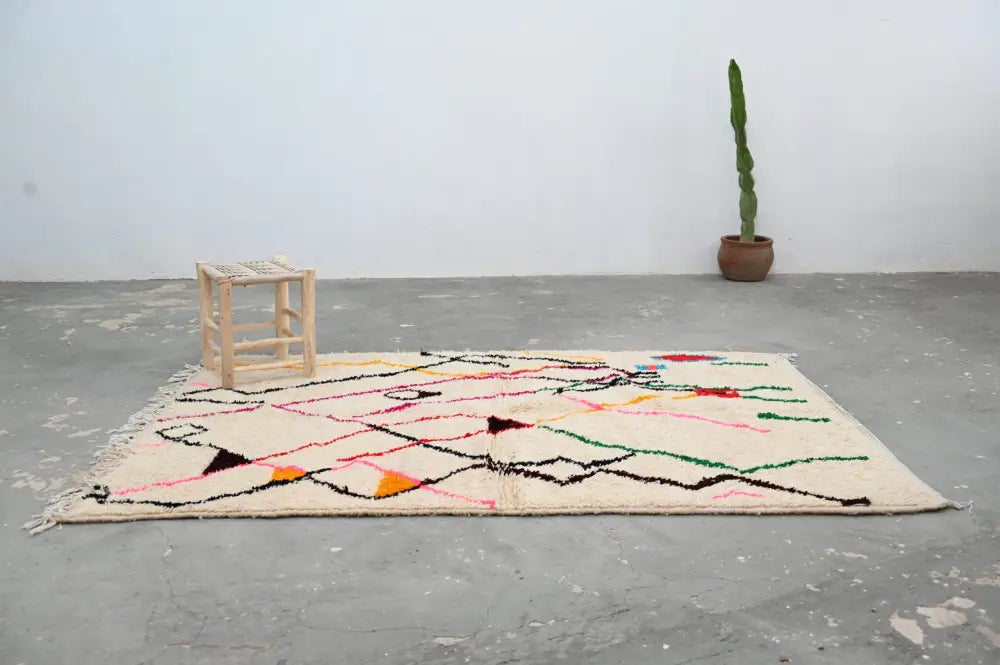 Beige moroccan handmade azilal rug with colorful black pink green and orange geometric patterns by decorbites