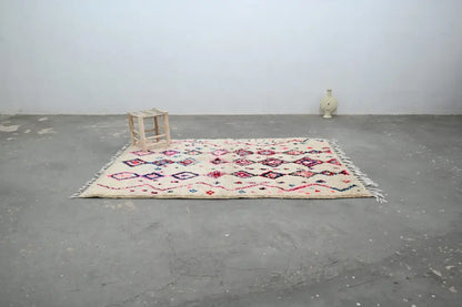 Beige DecorBites™ handmade traditional azilal rug with pink and red geometric patterns and fringed edges 230x154cm
